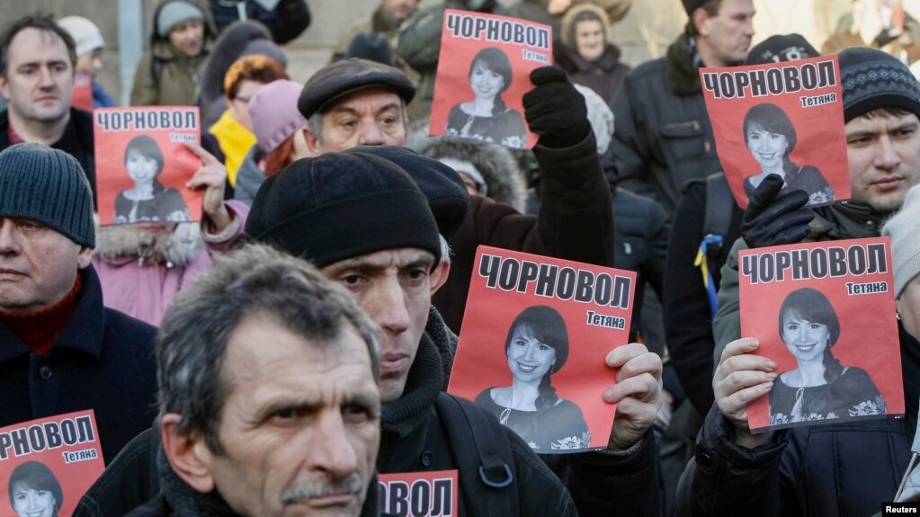 Protesters hold pictures of journalist Tetyana Chornovol, who was beaten hours after publishing an article on the assets of top government officials, during a December 25 rally in front of the Ukrainian Ministry of Internal Affairs in Kyiv.