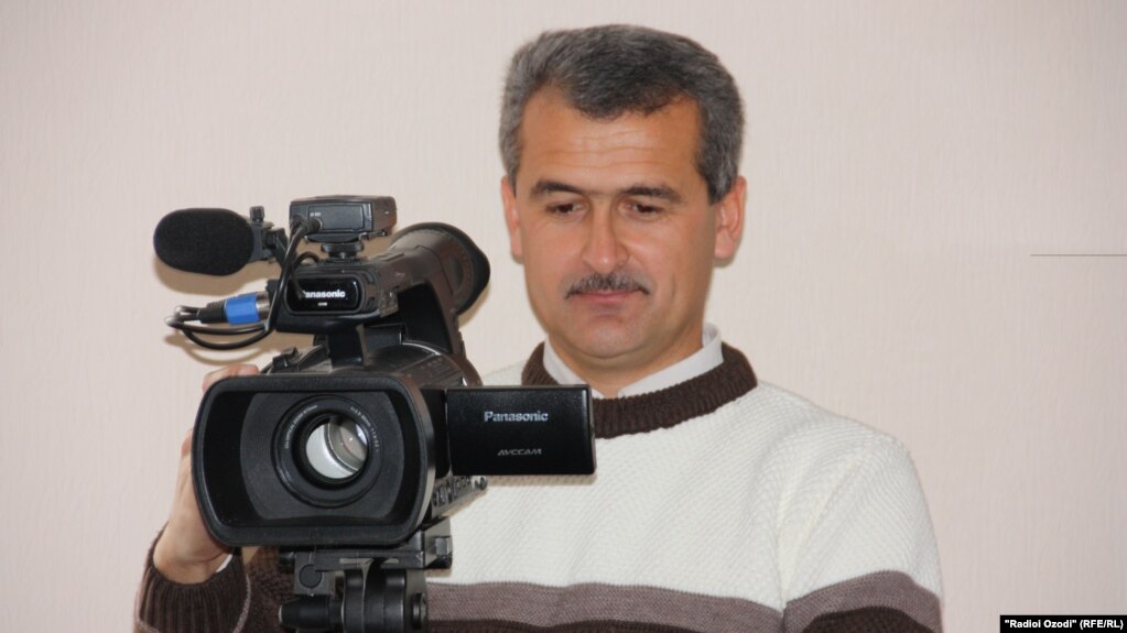 Barotali Nazarov holding a video camera.