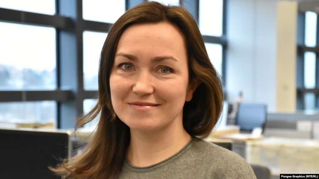 Alsu Kurmasheva stands in an office.