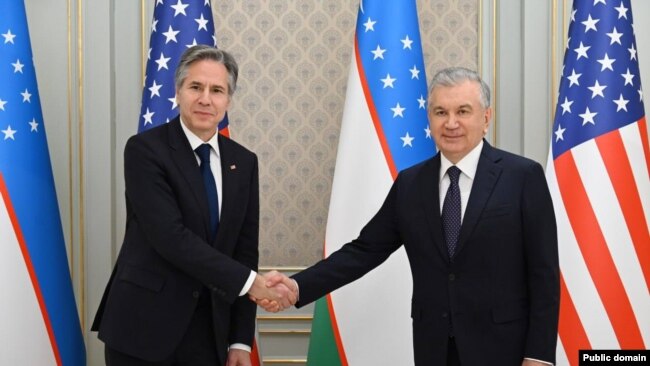 The President of Uzbekistan (R) shakes US Secretary of State Anthony Blinken's hand (L) in Tashkent.