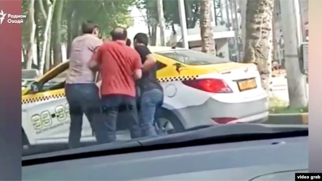 Three men appear to be forcing another into a car.