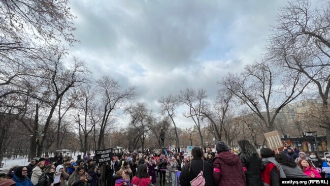 A group of activists protest in a snowy park.