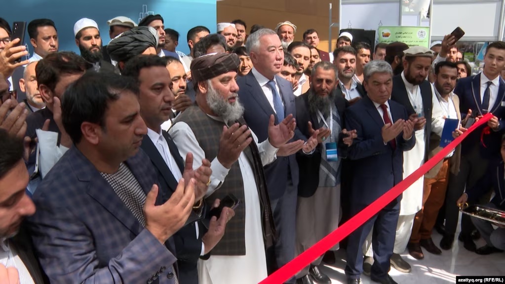 Several dozen men stand behind a red rope at the Kazakh-Afghan business forum.