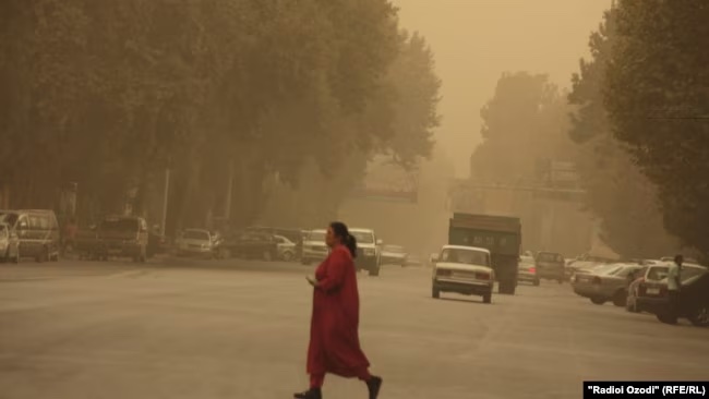 Image of a woman walking through a dust storm blowing through Dushanbe, Tajikistan from September 30, 2016