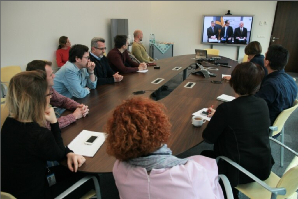 An image of RFE/RL journalists gathered around a table for the broadcast of the Balkan Service Certificate of Recognition Ceremony