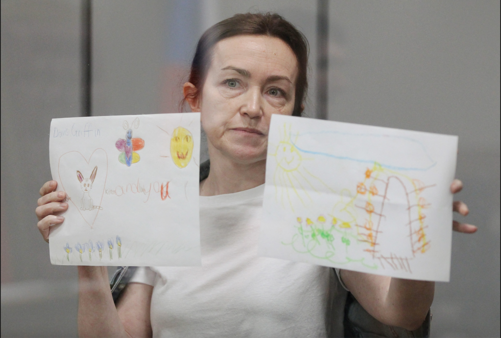 Russian-American journalist for Radio Free Europe/Radio Liberty (RFE/RL) Alsu Kurmasheva, who is in custody after she was accused of violating Russia's law on foreign agents, holds drawings by her supporters as she attends a court hearing in Kazan, Russia May 31, 2024. Image taken by REUTERS/Alexey Nasyrov.