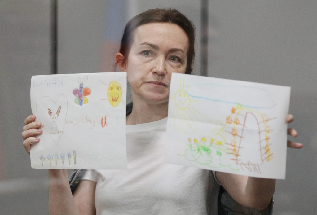 RFE/RL journalist Alsu Kurmasheva holds children’s drawings sent by her supporters as she attends a court hearing in Kazan, Russia, on May 31, 2024. “Considering that this is probably the only grass and trees I will see this summer, this is priceless," she said. (REUTERS/Alexey Nasyrov)