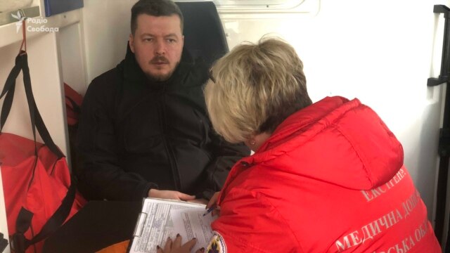 RFE/RL cameraman Borys Trotsenko, being treated by medical personnel after suffering a concussion while trying to report from a village council office near Kyiv, Ukraine (March 6, 2019)